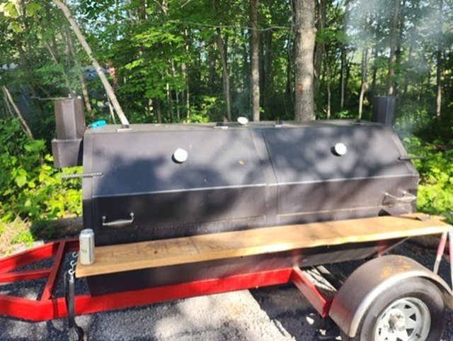 Hillside BBQ custom multi-chamber smoker on its trailer, smoking, with a stack at each end
